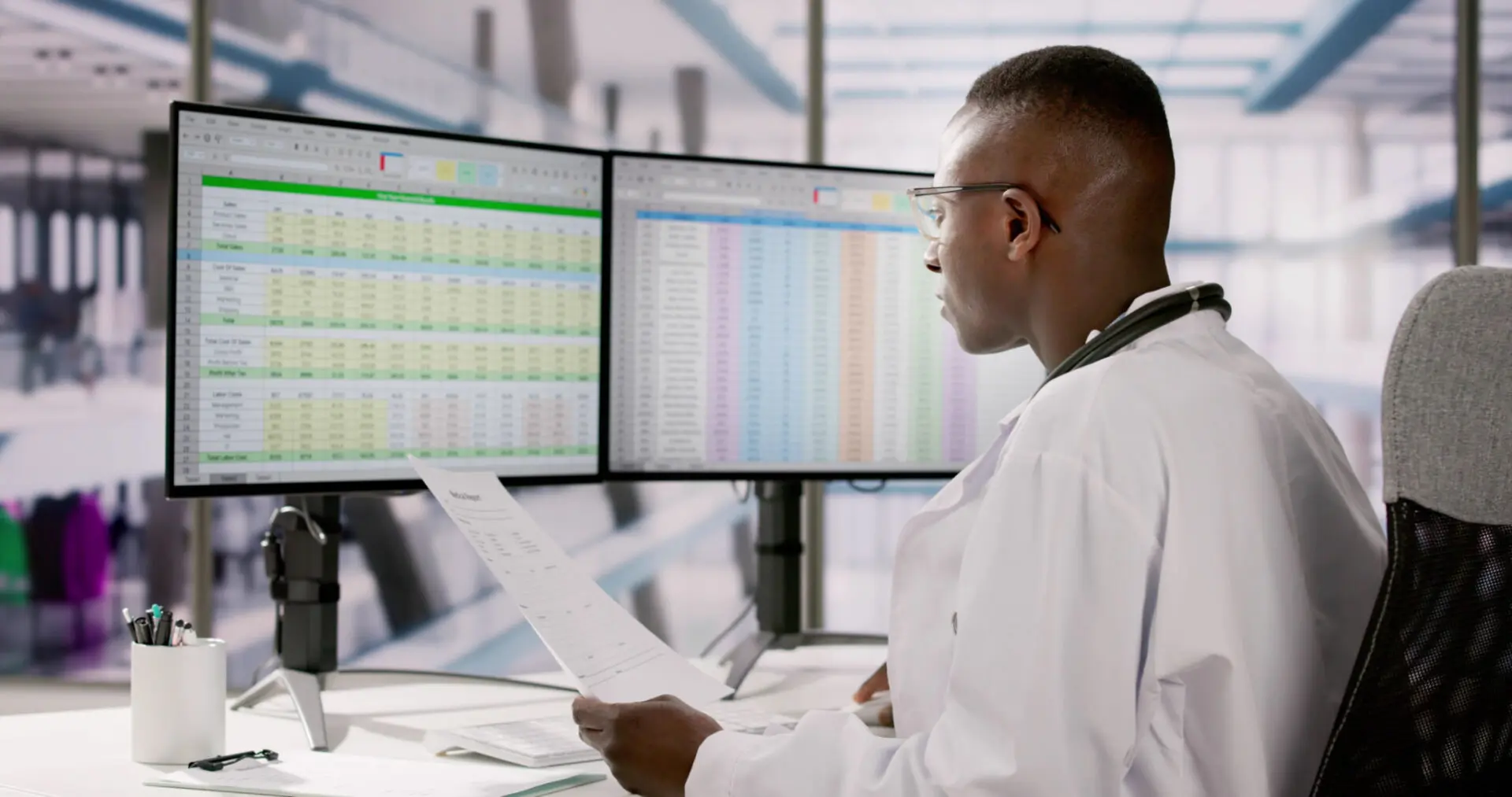 Doctor analyzing data on dual monitors.