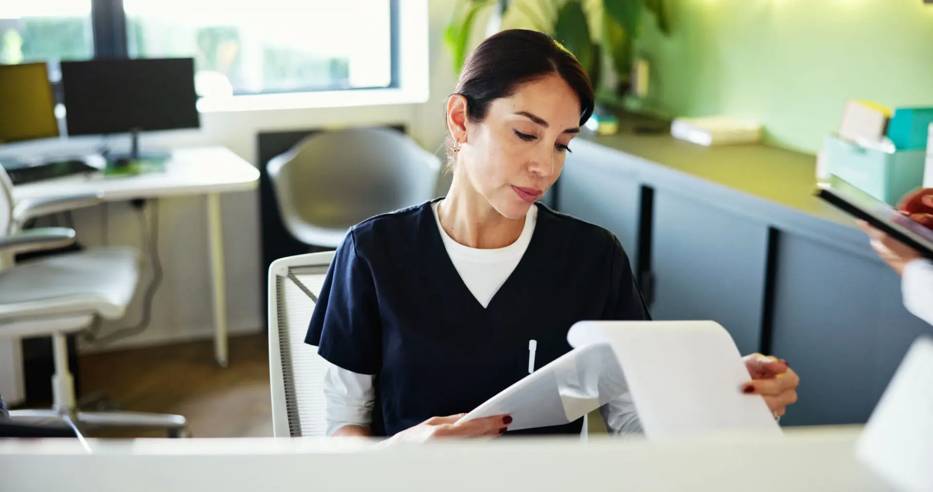 Woman reviewing documents at a desk.