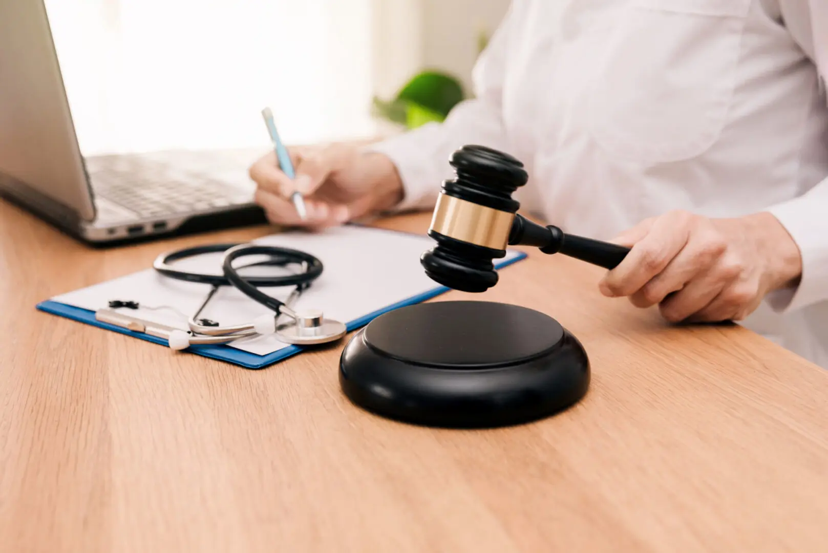 Gavel, stethoscope, and notes on desk.
